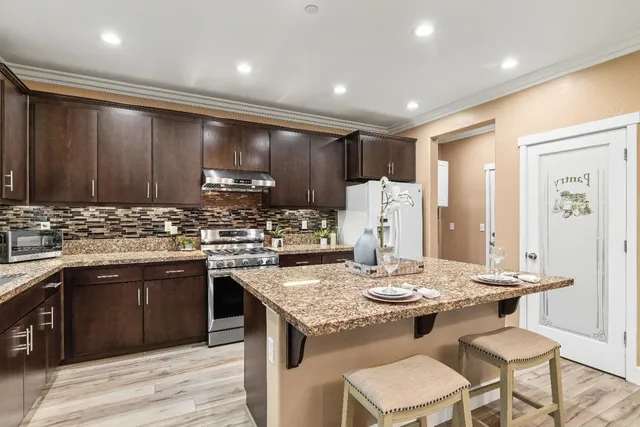a kitchen with stainless steel appliances granite countertop wooden cabinets sink and stove