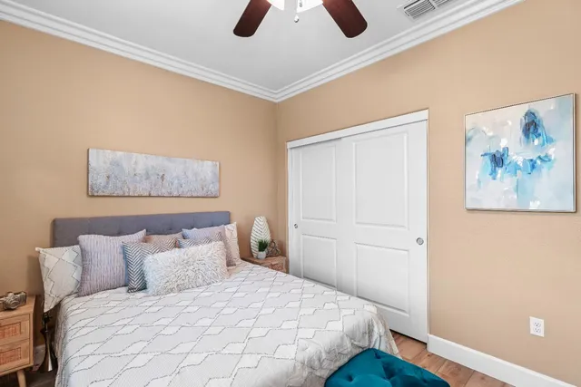 a spacious bedroom with a bed and wooden floor