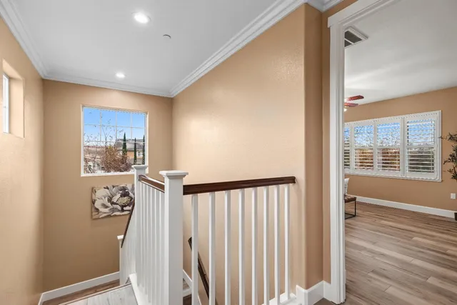 a bedroom with a bed and dresser with wooden floor