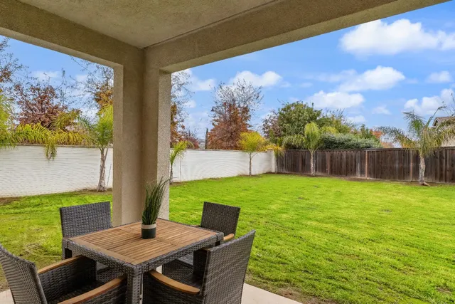 an aerial view of residential houses with outdoor space and lake view in back