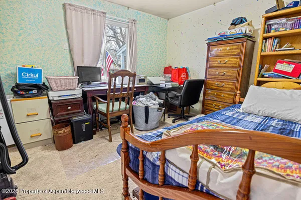 a bed sitting in a bedroom next to a window