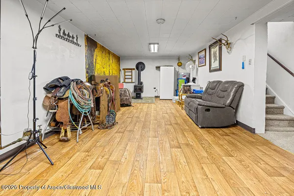 a view of a white house with a large tree and wooden fence