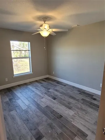 a view of an empty room with wooden floor
