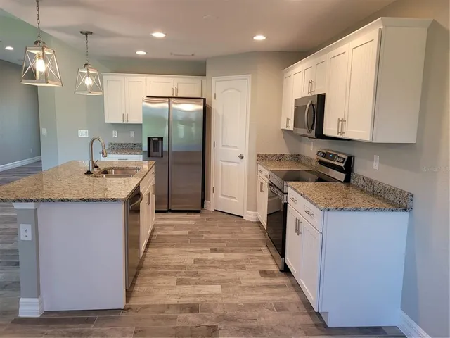 a kitchen with stainless steel appliances granite countertop a sink stove and refrigerator