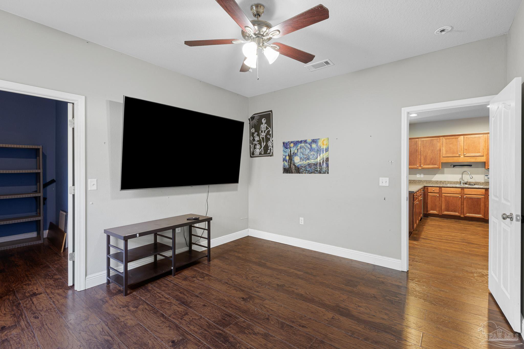 8855 Ridgebrook Court Pensacola, FL 32534 - Photo 17 of 37 a living room with flat screen tv and a ceiling fan