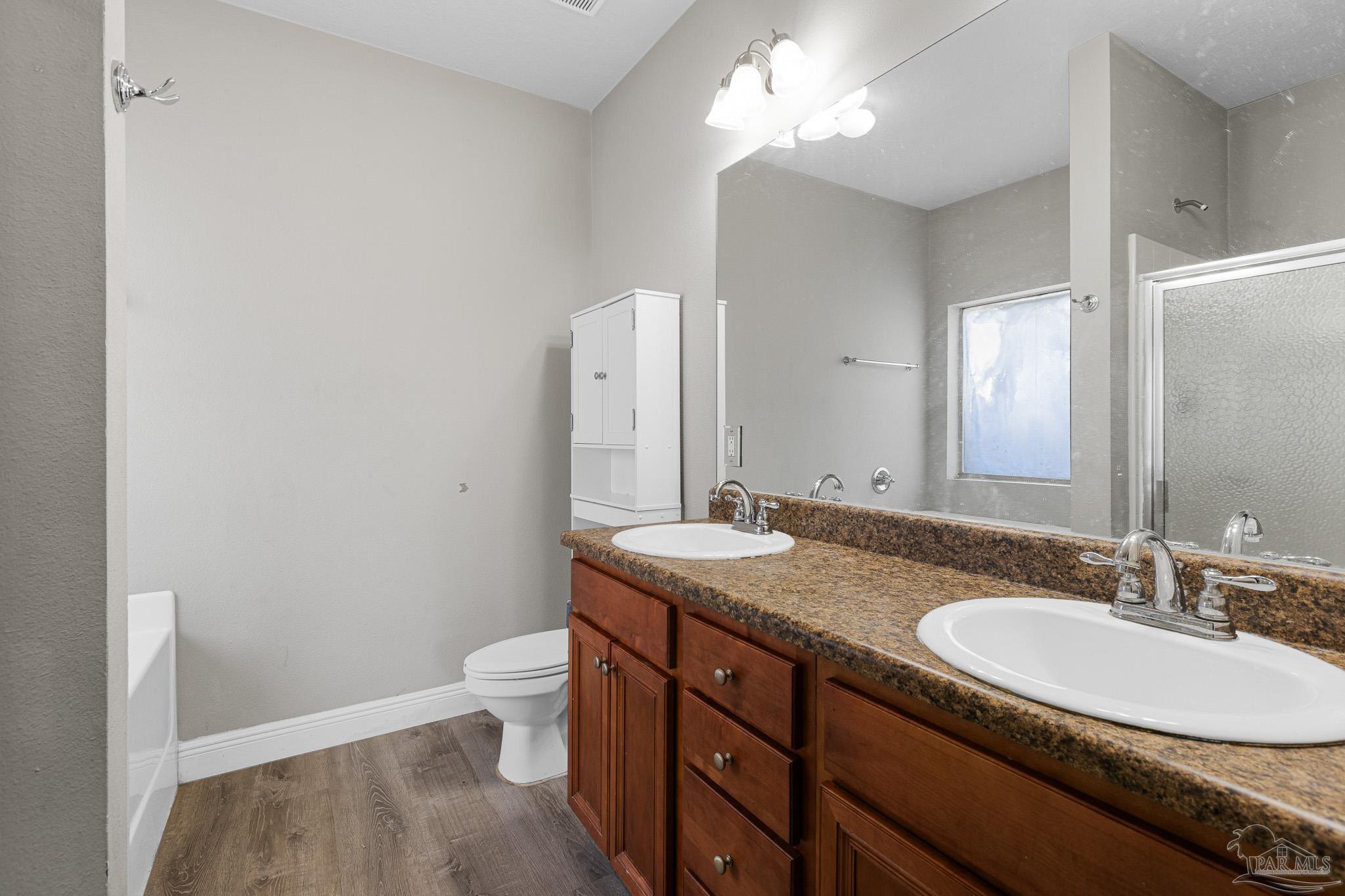 8855 Ridgebrook Court Pensacola, FL 32534 - Photo 21 of 37 a bathroom with a granite countertop sink a toilet and a mirror