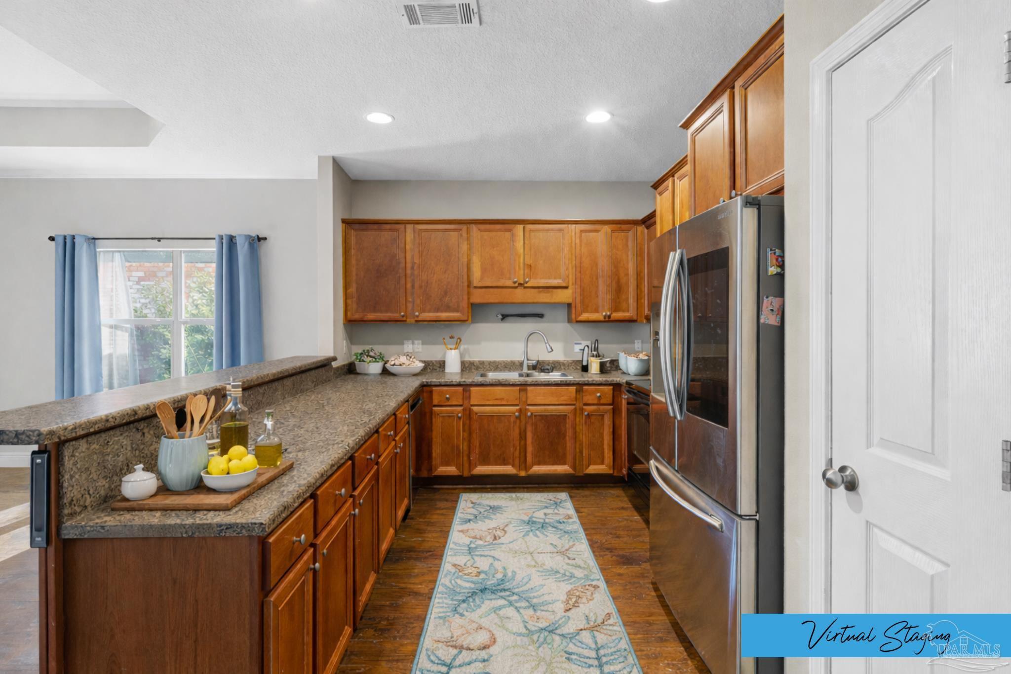 8855 Ridgebrook Court Pensacola, FL 32534 - Photo 10 of 37 a kitchen with a refrigerator a sink and cabinets