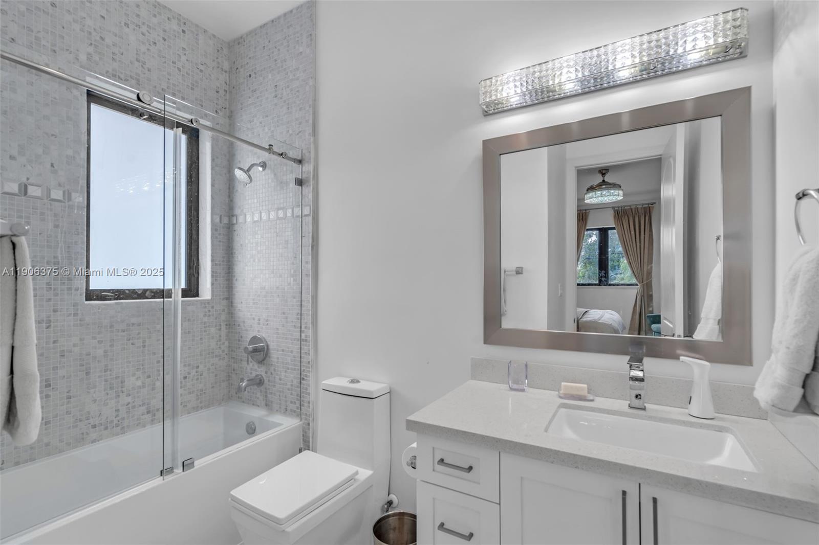 2085 Keystone Boulevard North Miami, FL 33181 - Photo 28 of 77 a bathroom with a sink double vanity mirror and a bathtub