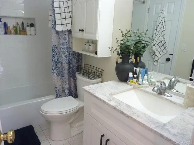a bathroom with a granite countertop sink a toilet and shower