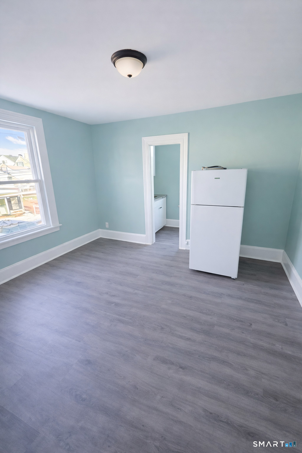 21 Pearl Street, Unit 2A Torrington, CT 06790 - Photo 2 of 5 an empty room with wooden floor and windows
