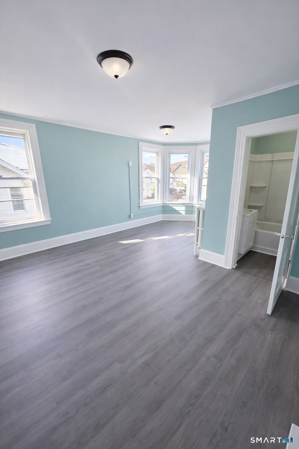 21 Pearl Street, Unit 2A Torrington, CT 06790 - Photo 3 of 5 an empty room with wooden floor and windows