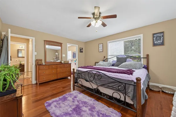 a bedroom with a bed a chandelier and dresser