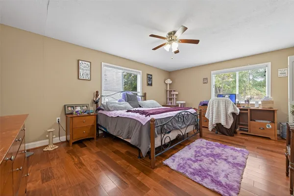 a bedroom with a bed and wooden floor