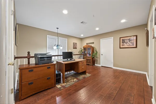a kitchen with stainless steel appliances granite countertop a refrigerator a sink dishwasher a stove and white countertops with wooden floor