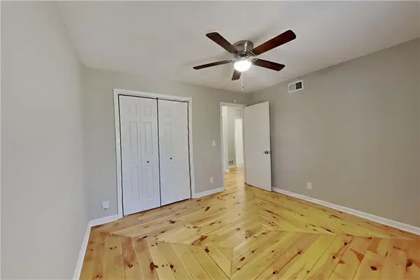 a view of a big room with wooden floor and windows