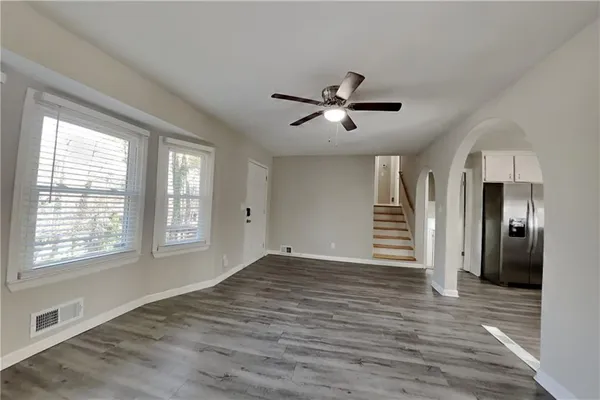a view of an empty room with a window and wooden floor