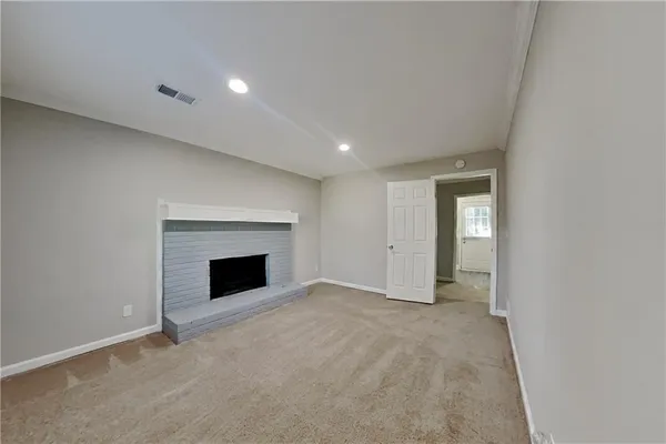 an empty room with windows and fireplace