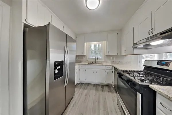 a kitchen with a sink stove and refrigerator