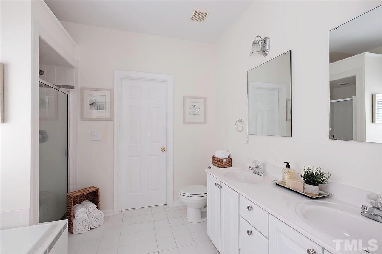 7924 Milltrace Run Raleigh, NC 27615 - Photo 12 of 25 a spacious bathroom with a granite countertop sink a toilet and a mirror