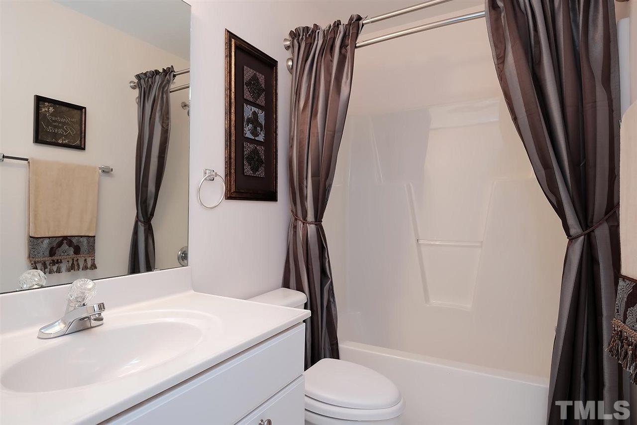 7924 Milltrace Run Raleigh, NC 27615 - Photo 17 of 25 a bathroom with a sink a toilet a tub and shower