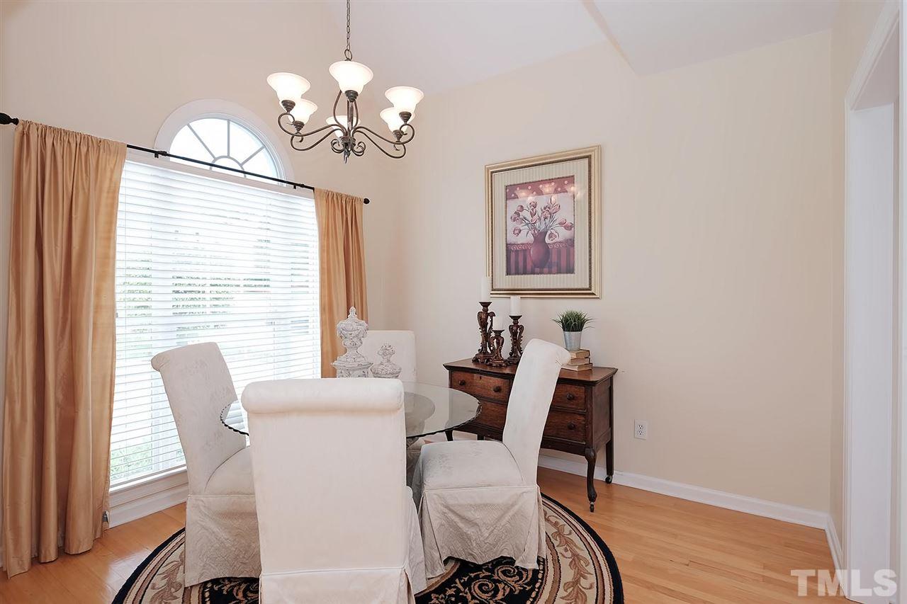 7924 Milltrace Run Raleigh, NC 27615 - Photo 3 of 25 a view of a dining room with furniture a chandelier and wooden floor