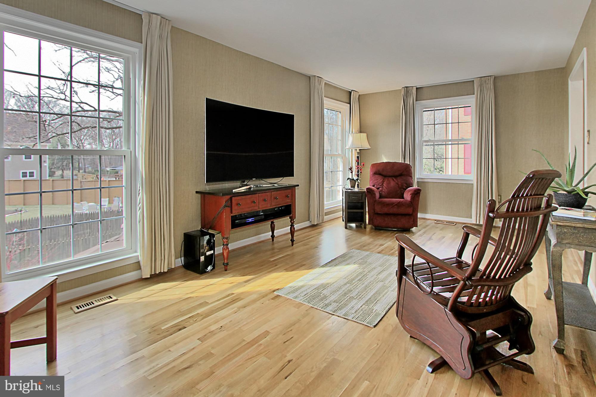 7013 Leestone Street Springfield, VA 22151 - Photo 14 of 36 a living room with furniture a flat screen tv and a large window