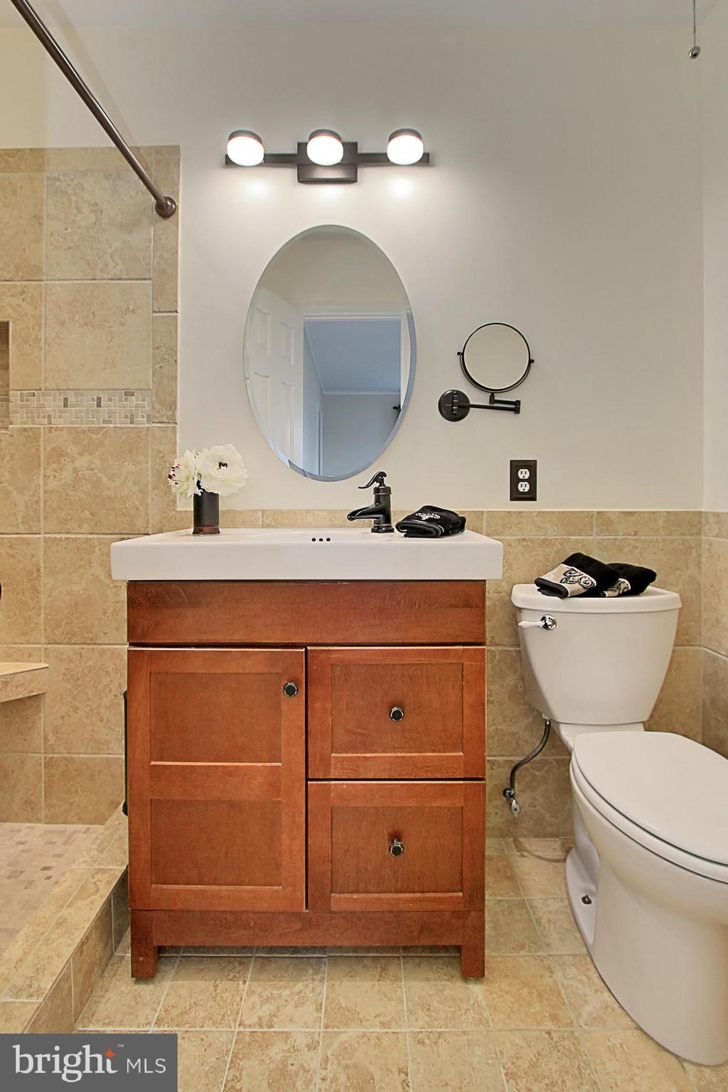 7013 Leestone Street Springfield, VA 22151 - Photo 23 of 36 a bathroom with a toilet sink and mirror
