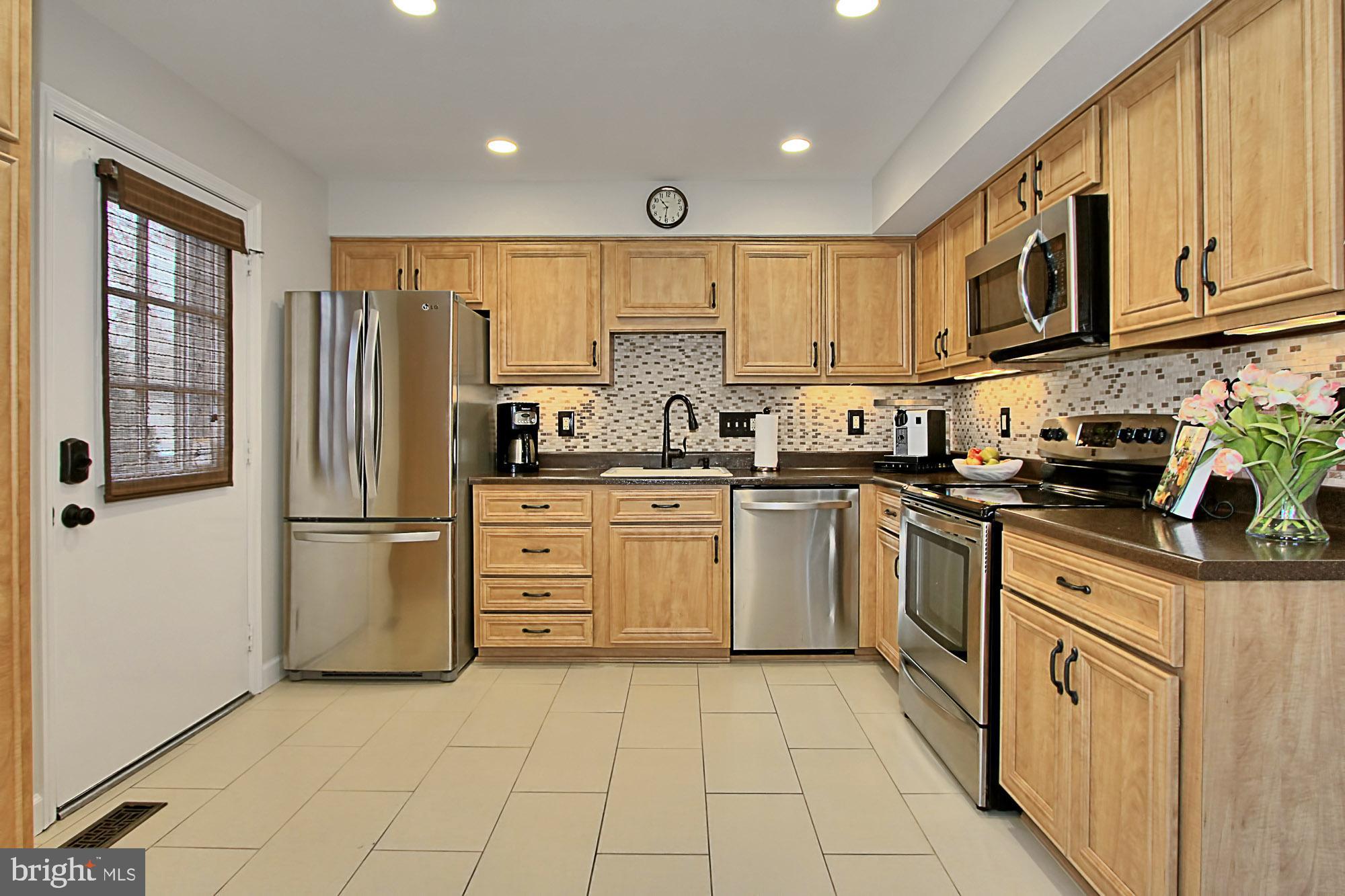 7013 Leestone Street Springfield, VA 22151 - Photo 5 of 36 a kitchen with stainless steel appliances granite countertop a refrigerator sink and cabinets