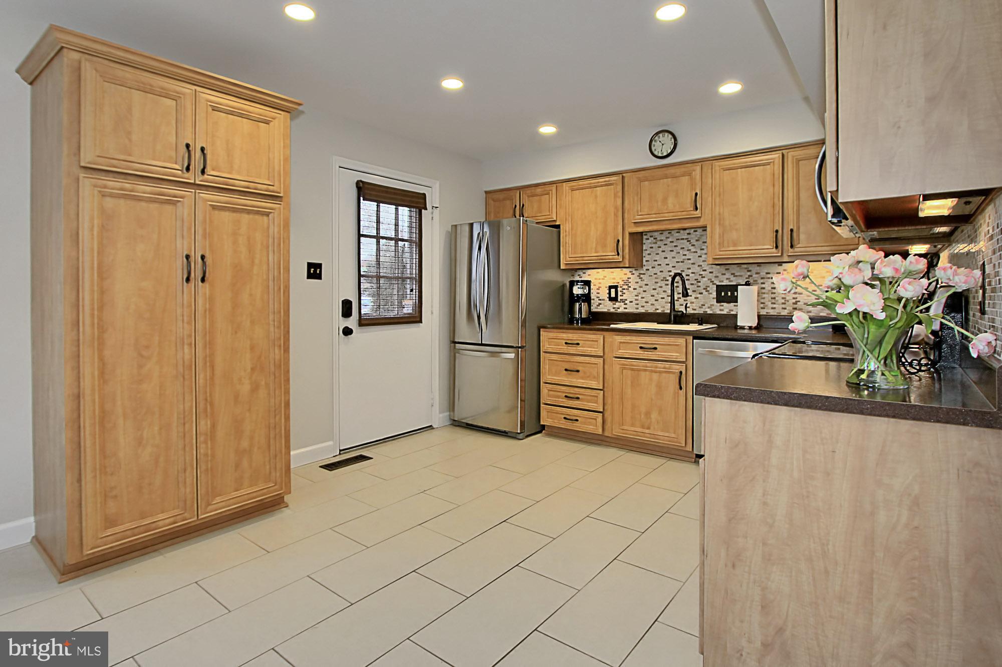 7013 Leestone Street Springfield, VA 22151 - Photo 6 of 36 a kitchen with stainless steel appliances granite countertop a refrigerator sink and cabinets