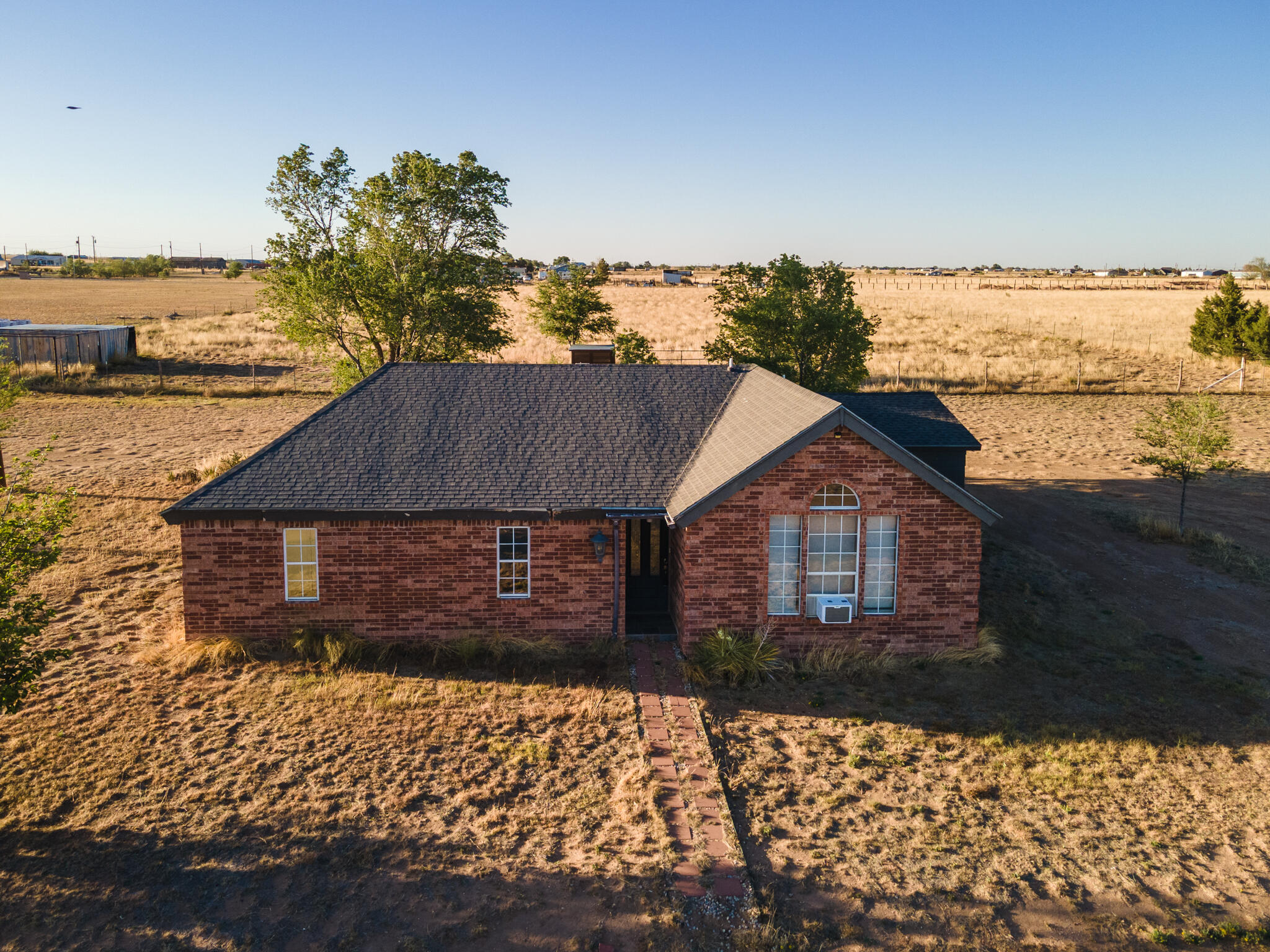 6917 Highway 114 Lubbock, TX 79407 - Photo 3 of 45 a front view of a house with a yard and lake view