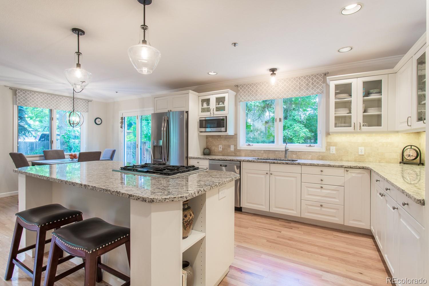 1151 Juniper Avenue Boulder, CO 80304 - Photo 8 of 37 a kitchen with kitchen island granite countertop a stove a sink a center island and windows