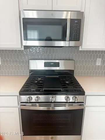 a stove top oven sitting inside of a kitchen