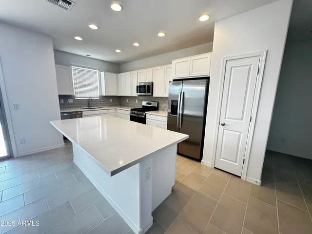 a kitchen with stainless steel appliances a refrigerator sink and microwave