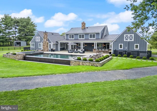 a front view of a house with a yard and potted plants