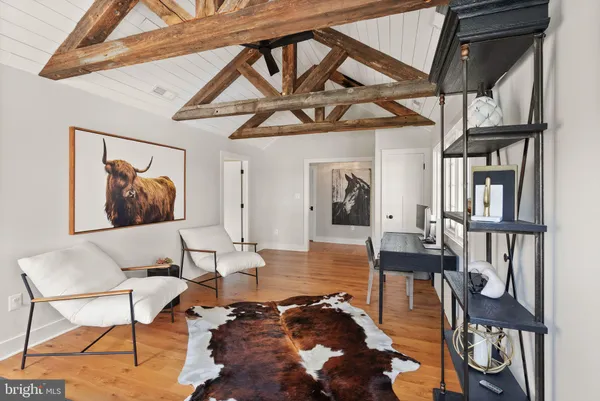 a view of swimming pool with seating space and trees in the background