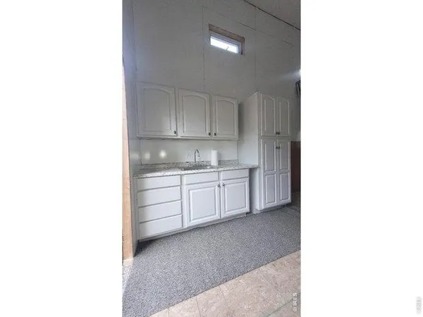 a kitchen with granite countertop white cabinets and white appliances