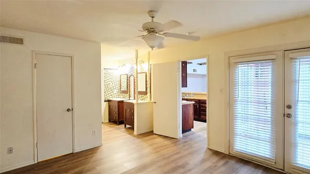 a view of a kitchen with a refrigerator a ceiling fan and wooden floor