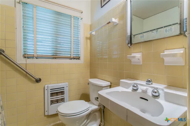 a bathroom with a sink a toilet and a mirror