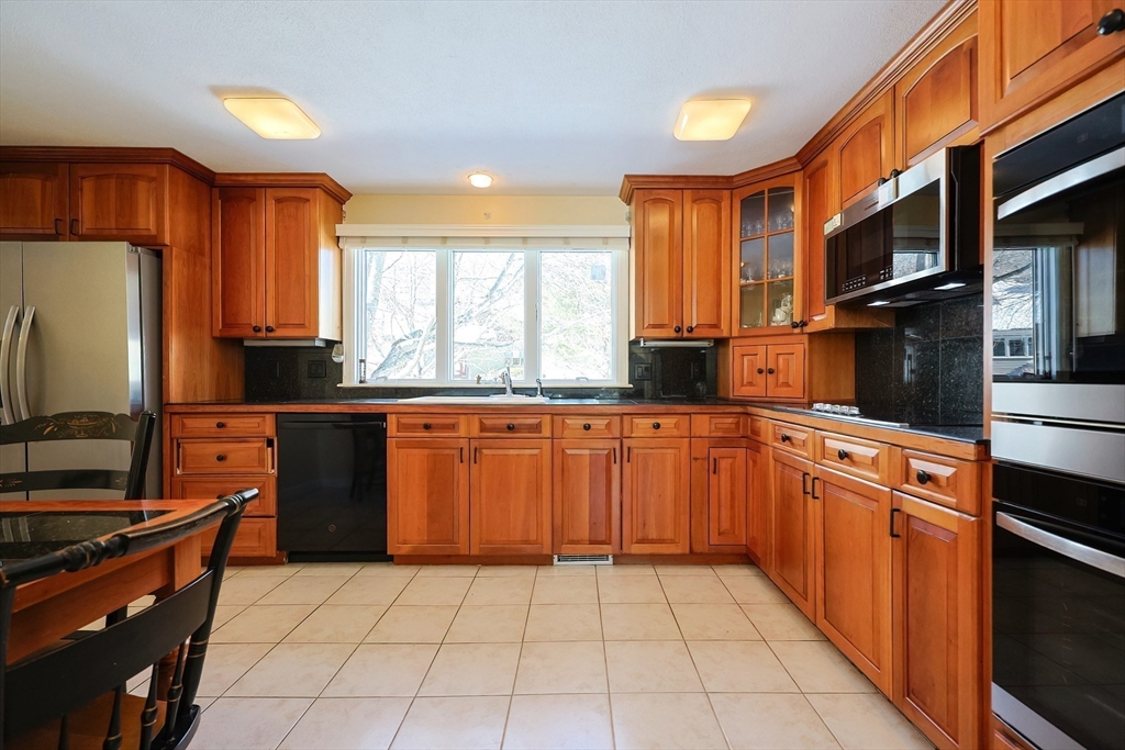 93 Potter Pond, Unit 93 Lexington, MA 02421 - Photo 16 of 42 a kitchen with stainless steel appliances granite countertop a stove a sink and a refrigerator
