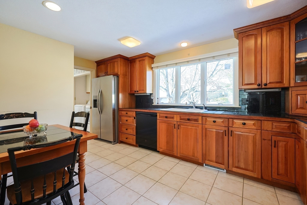 93 Potter Pond, Unit 93 Lexington, MA 02421 - Photo 17 of 42 a kitchen with granite countertop a refrigerator stove top oven dining table and chairs