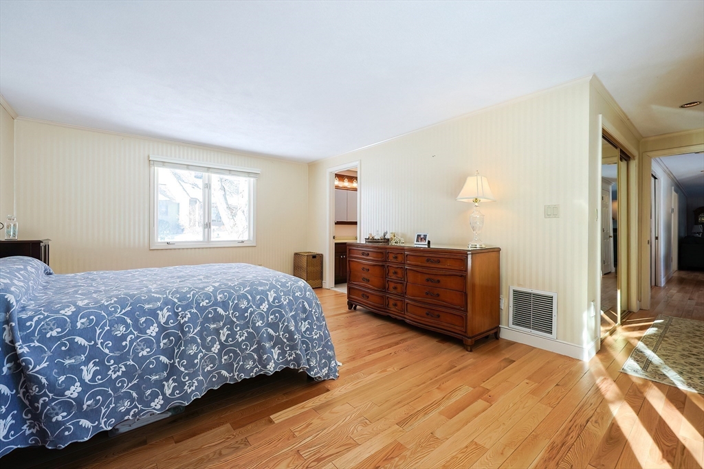 93 Potter Pond, Unit 93 Lexington, MA 02421 - Photo 25 of 42 a bedroom with a bed and wooden floor