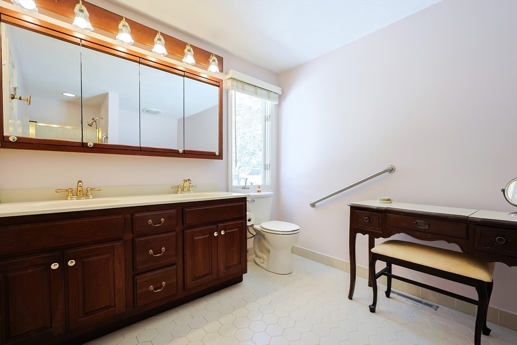 93 Potter Pond, Unit 93 Lexington, MA 02421 - Photo 28 of 42 a spacious bathroom with a toilet a sink and mirror