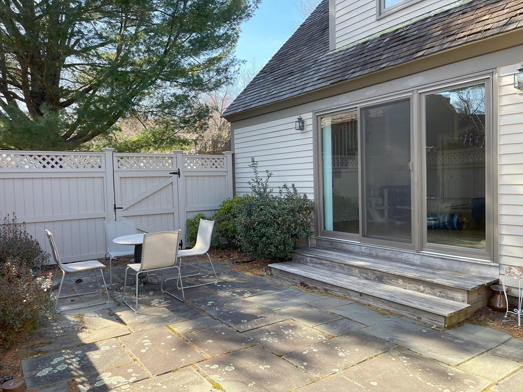 93 Potter Pond, Unit 93 Lexington, MA 02421 - Photo 38 of 42 a view of a chair and table in backyard of the house