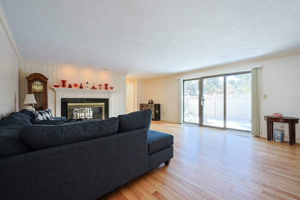 93 Potter Pond, Unit 93 Lexington, MA 02421 - Photo 9 of 42 a living room with furniture and a fireplace