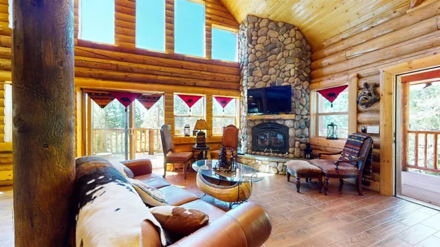 a living room with fireplace furniture and a large window