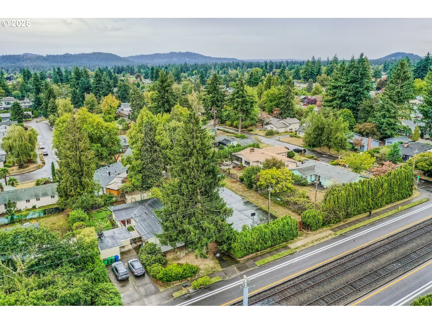 15590 East Burnside Street Portland, OR 97233 - Photo 6 of 11 an aerial view of a house with lots of residential buildings green landscape and mountain view