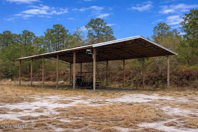 a backyard of a house with table and chairs under an umbrella