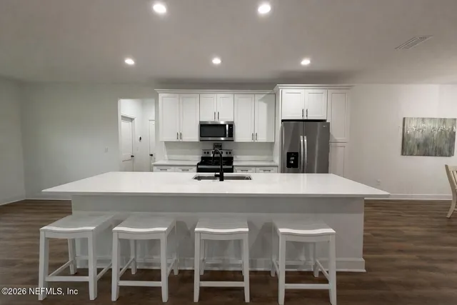 a kitchen with cabinets a sink oven and refrigerator