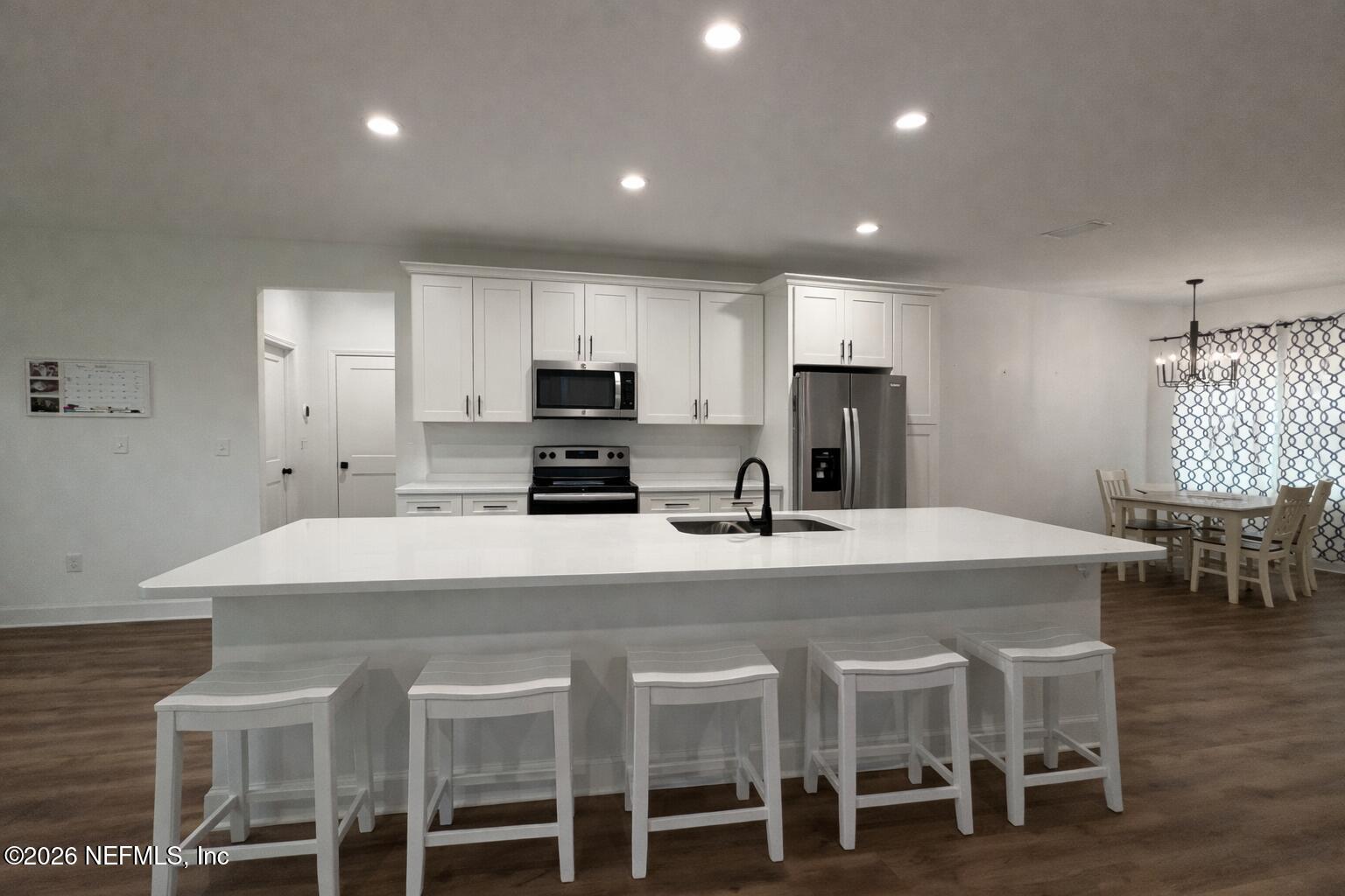 5012 Laurel Street Middleburg, FL 32068 - Photo 5 of 33 a kitchen with microwave a refrigerator and chairs