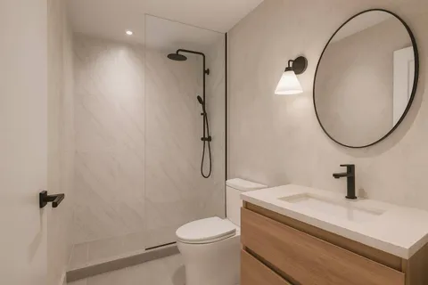 a bathroom with a sink a toilet and a mirror